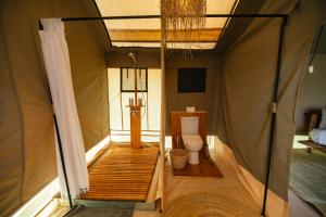 a bathroom with a toilet in a tent at Entepesi Tented Camp in Musiara Campsite