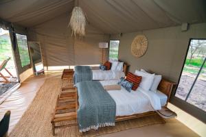 a bedroom with a bed and a couch in a tent at Entepesi Tented Camp in Musiara Campsite
