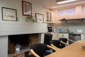 a kitchen with a fireplace and a table and chairs at The Cozy Oslo Stay in Oslo