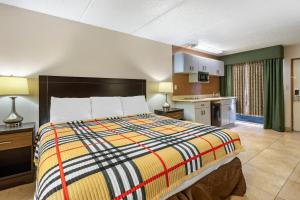 a bedroom with a large bed and a kitchen at Rodeway Inn Clearwater-Dunedin in Clearwater