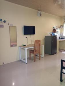 a room with a desk with a television and a chair at Bluewaves Apartment, scooter in Dauis