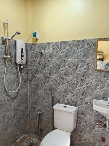 a bathroom with a toilet and a shower and a sink at Bluewaves Apartment, scooter in Dauis +12 photos
