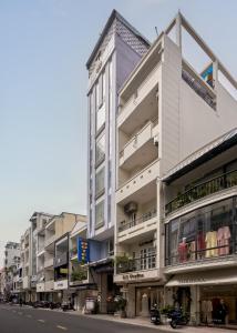 a tall white building on the side of a street at Quy Hung Hotel And Spa Central in Ho Chi Minh City
