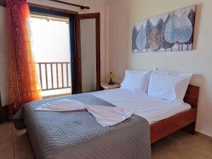 a bedroom with a bed with white sheets and a window at XD Al Mare in Ierissos