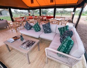a living room with a white couch and a table at Entepesi Tented Camp in Musiara Campsite