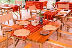 a wooden table with plates and dishes on it at Entepesi Tented Camp in Musiara Campsite +19 photos