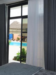 a bedroom with a window with a view of a pool at Wayma Paradise Resort in Jambiani
