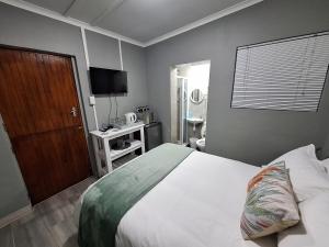 a bedroom with a large bed and a television at Stay a While Self catering - Close to Greenacres Hospital, free Wi-Fi, and secure parking in Newton Park +7 photos