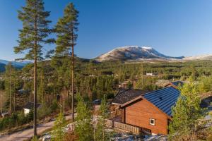 a cabin in the woods with mountains in the background at Solstråle Hytte 6p in Vradal