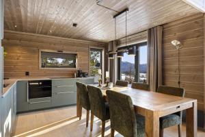 a kitchen and dining room with a table and chairs at Lothlórien Lodge 8p Sauna in Vradal