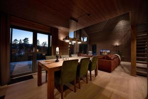 a dining room with a table and chairs and a couch at Lothlórien Lodge 8p Sauna in Vradal +25 photos