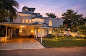 a large white house with a driveway at De Lavender Villa 1 in Citaringgul 1