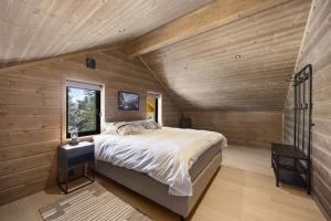 a bedroom with a large bed in a room with wooden walls at Lothlórien Lodge 8p Sauna in Vradal