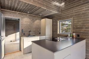 a kitchen with white cabinets and a black counter top at Berre Veit 6p in Vradal +21 photos