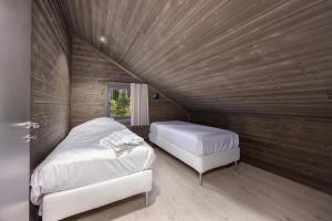 two beds in a room with a wooden ceiling at Berre Veit 6p in Vradal