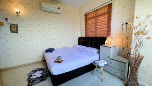 a bedroom with a bed with a nightstand and a window at Beachfront Bliss Sea View Glory Beach PD Homestay in Port Dickson