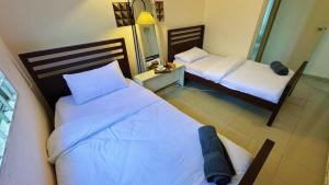 a bedroom with two beds and a mirror at Beachfront Bliss Sea View Glory Beach PD Homestay in Port Dickson