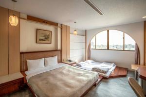 a bedroom with two beds and a large window at Hwa Nan Hotel in Yongkang