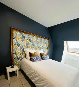 a bedroom with a large bed with a blue wall at Maison Panorama avec terrasse exposition sud in Mers-les-Bains