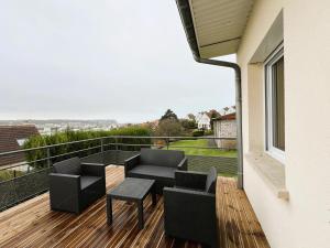 a patio with a couch and chairs on a deck at Maison Panorama avec terrasse exposition sud in Mers-les-Bains