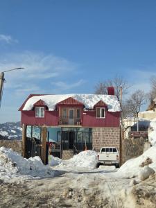 a red house with snow on top of it at Guest House Nukri in Danisparauli