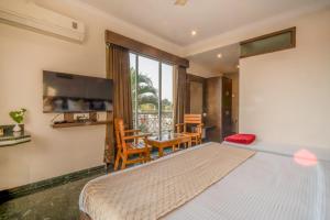 a bedroom with a bed and a table and a chair at HOTEL KB's Grand in Shirdi +58 photos