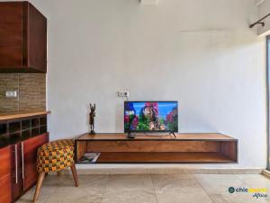 a tv sitting on top of a wooden entertainment center at Chic studio with amazing view in Yaoundé