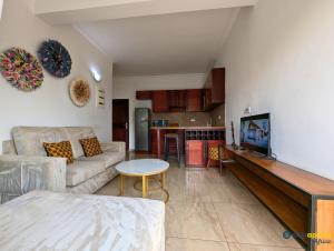 a living room with a couch and a flat screen tv at Chic studio with amazing view in Yaoundé