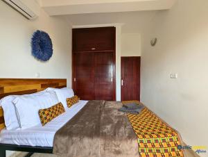 a bedroom with a large bed and a wooden door at Chic studio with amazing view in Yaoundé +3 photos