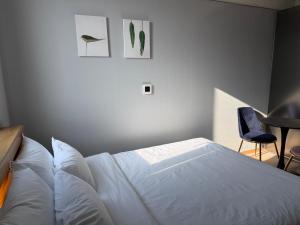 a bedroom with a white bed and a blue chair at Sky Star in Incheon