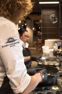 a woman standing in a kitchen preparing food at Hotel Riet I Kloeg Collection in Koudekerke