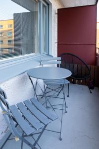 a table and chairs on a balcony with a window at Bright apartment in the Center in Kajaani
