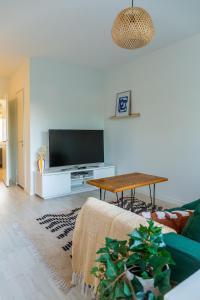 a living room with a tv and a table at Bright apartment in the Center in Kajaani
