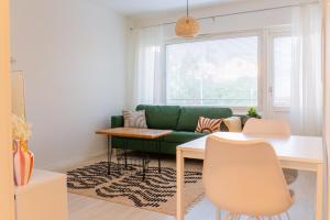 a living room with a green couch and a table at Bright apartment in the Center in Kajaani