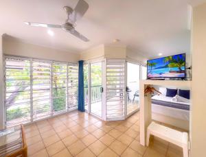 a bedroom with a bed and a balcony with windows at Tropic Drift in Airlie Beach +47 photos