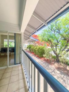 a balcony of a house with a view of the garden at Tropic Drift in Airlie Beach