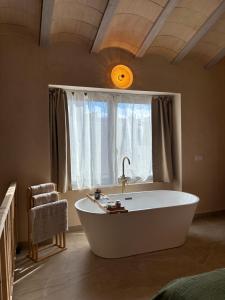 a large bath tub in a room with a window at Suite ideal para escapadas romanticas in Bullas