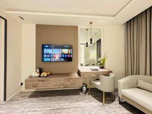 a living room with a television on a wall at Taj Signature Hotel - F7 Markaz Islamabad in Islamabad
