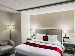 a hotel room with a large bed and a chair at Taj Signature Hotel - F7 Markaz Islamabad in Islamabad