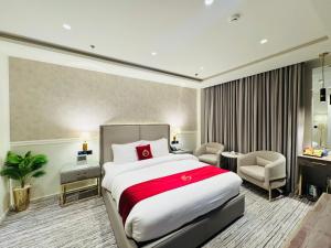 a hotel room with a large bed and a chair at Taj Signature Hotel - F7 Markaz Islamabad in Islamabad
