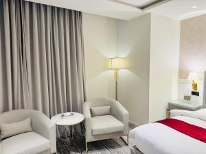 a hotel room with a bed and a chair at Taj Signature Hotel - F7 Markaz Islamabad in Islamabad