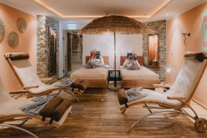 a room with two beds with chairs and an umbrella at Sylvana's Wohlfühl Hotel in Mayrhofen +131 photos
