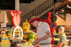 a man standing in front of a display of fruits and vegetables at Sevonra Beach Resort in Unawatuna