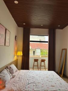 a bedroom with a bed and a view of a balcony at Nhà Bơ Homestay 2 in Danang