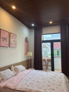 a bedroom with a large bed and a window at Nhà Bơ Homestay 2 in Danang