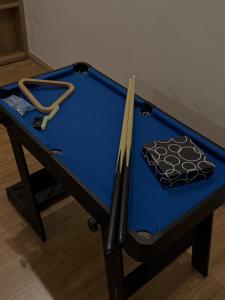a blue ping pong table with sticks on it at Nhà Bơ Homestay 2 in Danang