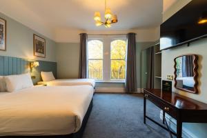 a hotel room with two beds and a window at Sefton Park Hotel in Liverpool