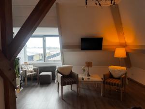 a living room with a table and chairs and a tv at Bed en Bike Oudeschild in Oudeschild