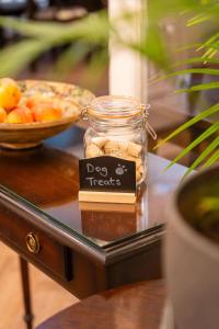 a jar of dog treats on a table with a bowl of fruit at Sefton Park Hotel in Liverpool +27 photos