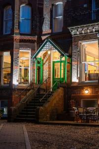 a building with green doors and stairs in front at Sefton Park Hotel in Liverpool